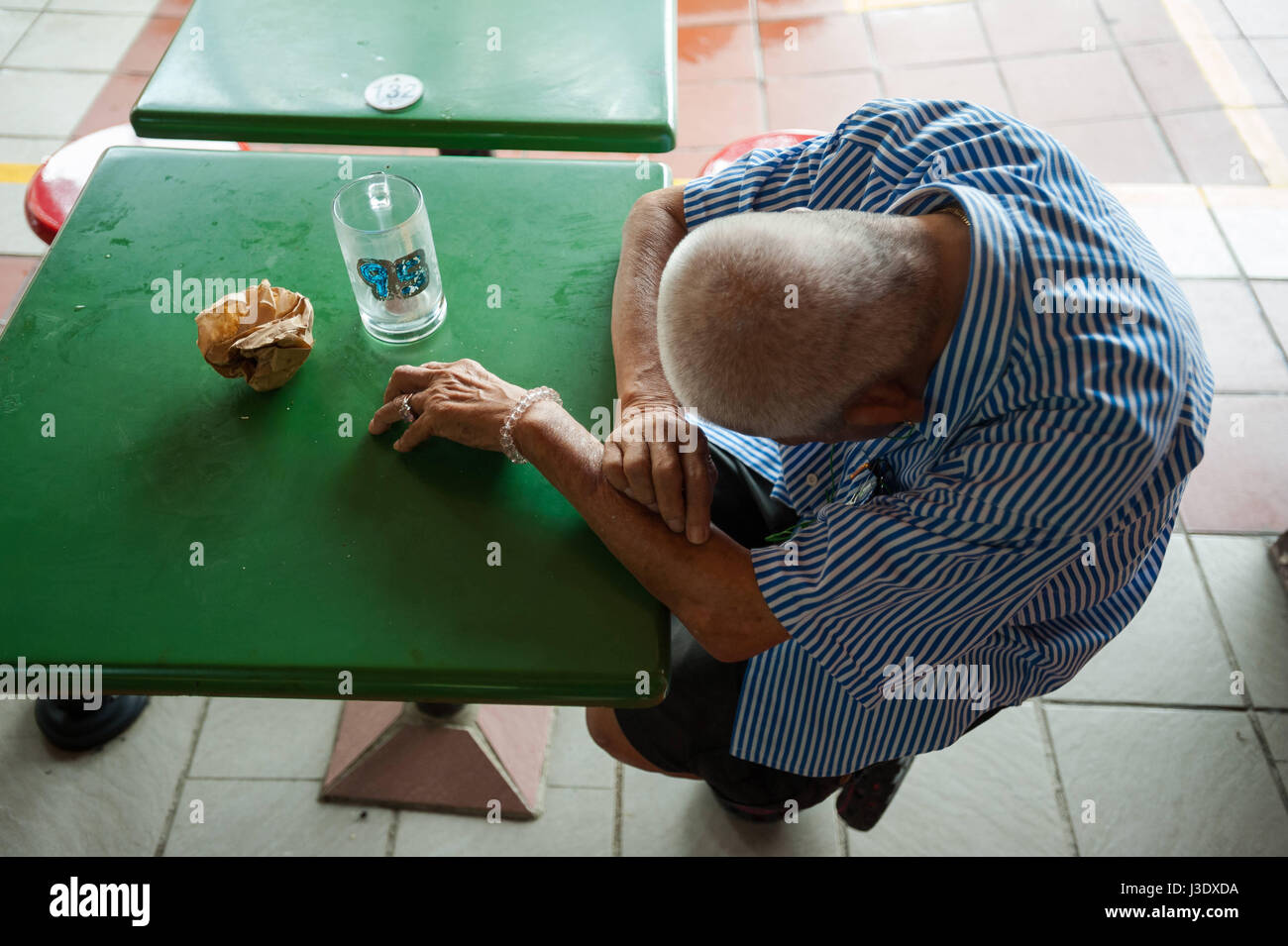Singapour, République de Singapour, un homme revient à une table Banque D'Images