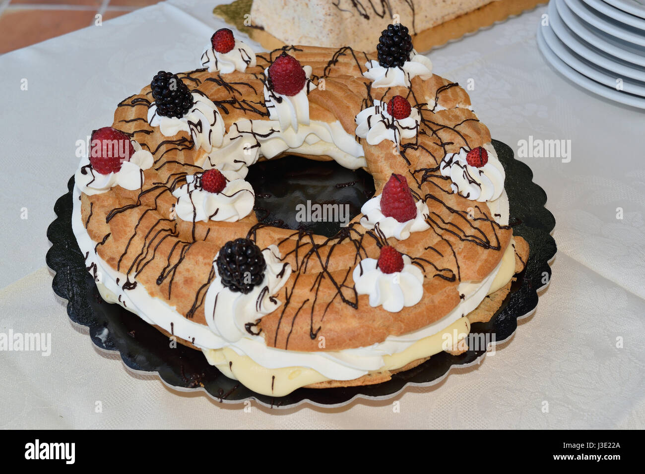 Beignet farci avec de la crème et garni de fruits Banque D'Images