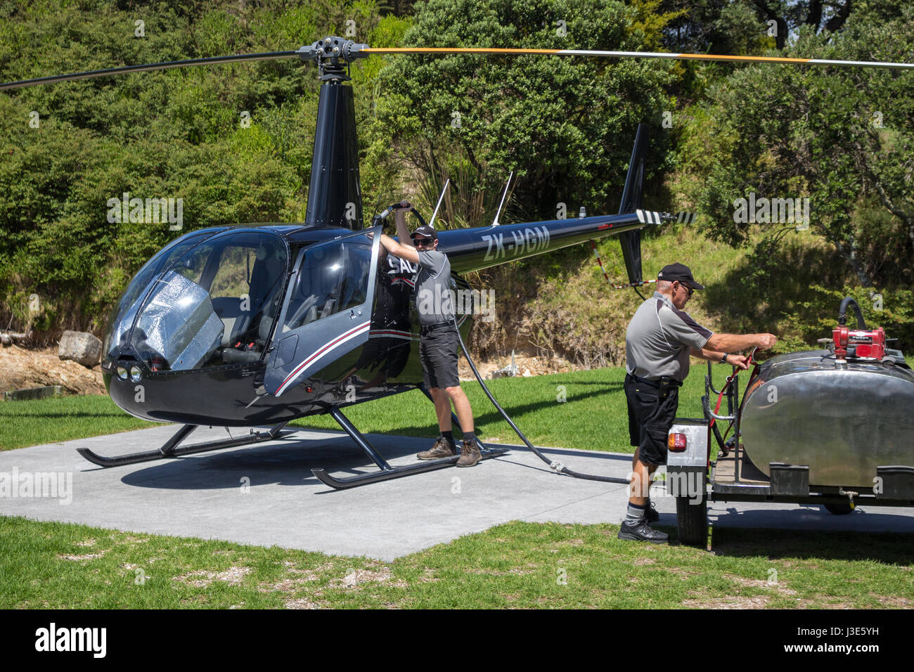 Paihia Bay of Islands, Northland Nouvelle-Zélande - Février 21th, 2017 : un pilote et un assistant sont un ravitaillement en hélicoptère Robinson R44 Raven II, sur l'hôtel Banque D'Images