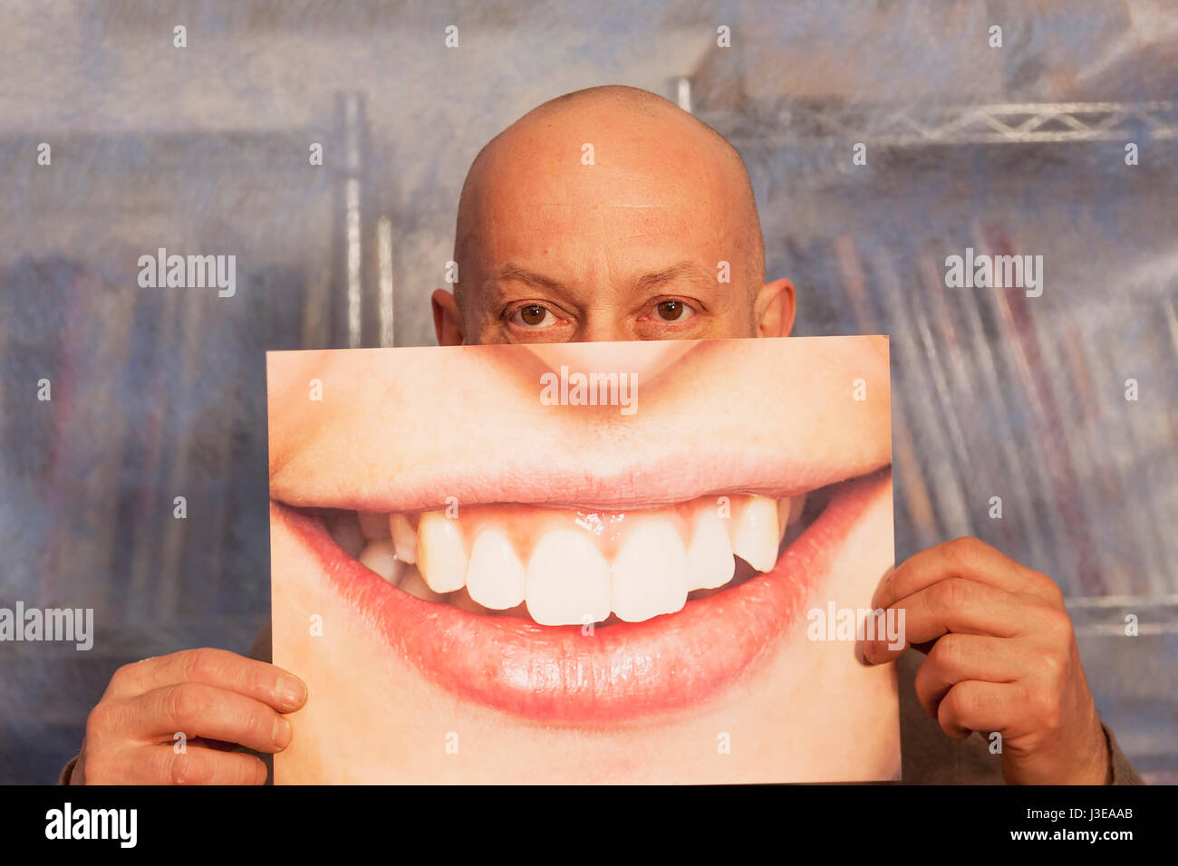 Homme chauve tenant une carte avec un grand sourire sur elle Banque D'Images