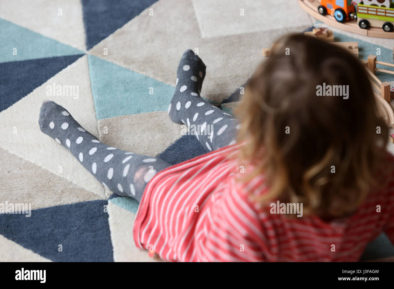 Une jeune fillette de deux ans sur la photo en jouant avec des jouets en bois dans son salon à son domicile à Sussex, UK. Banque D'Images