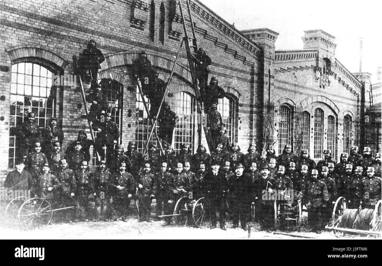 L'image représente une photographie historique des pompiers (Feuerwehr) à RAW Salbke, en Allemagne, montrant l'équipement et le personnel utilisés par les pompiers au début du XXe siècle. La caserne de pompiers et ses opérations soulignent le développement de méthodes de lutte contre les incendies et la sécurité communautaire pendant cette période. Banque D'Images
