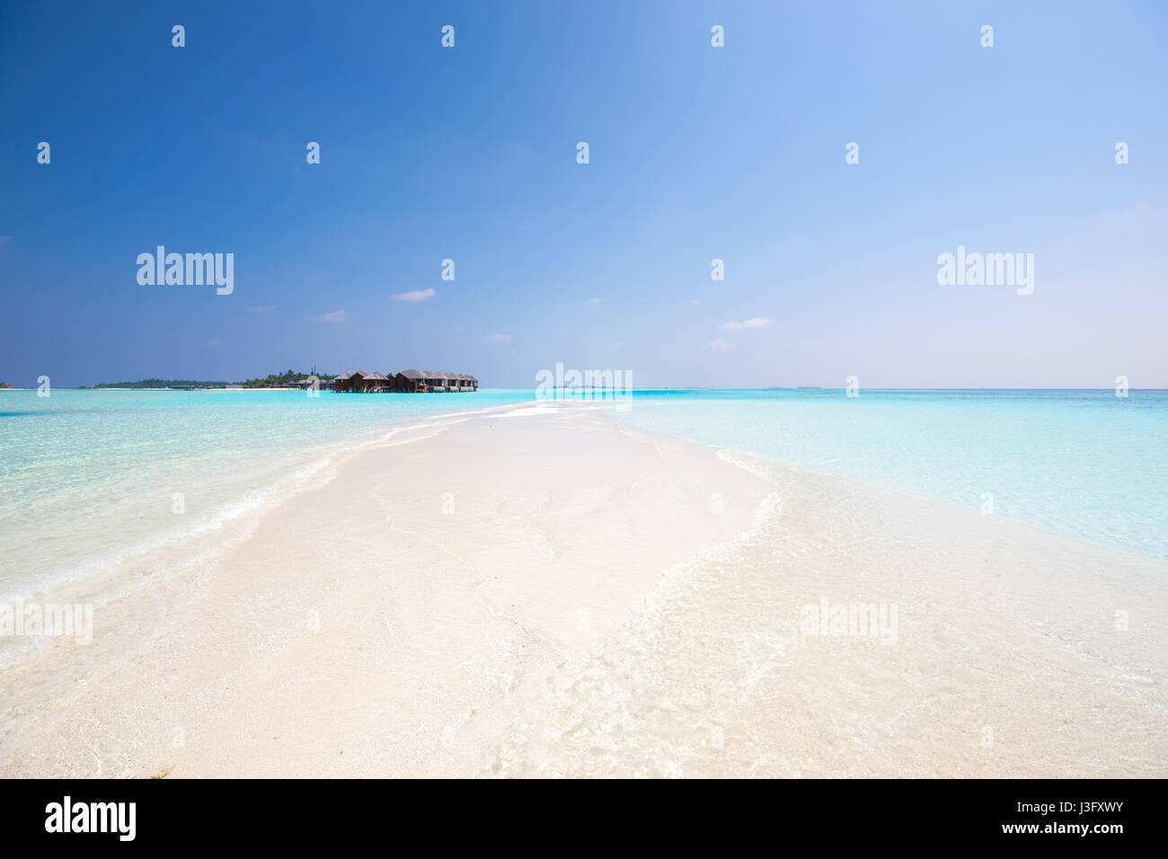 Sand Bar tropical à plus de bungalows sur pilotis avec Crystal Clear de l'eau de l'océan bleu turquoise Banque D'Images