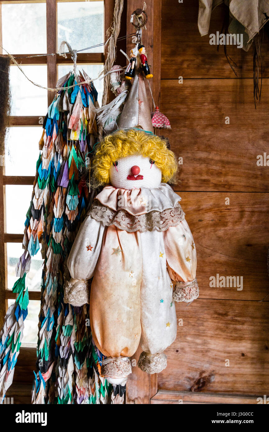 Le Japon, Ehime, Uwajima. Taga de culte. Clown rag doll pendaison le mur dans le petit bâtiment de culte en bois. Banque D'Images