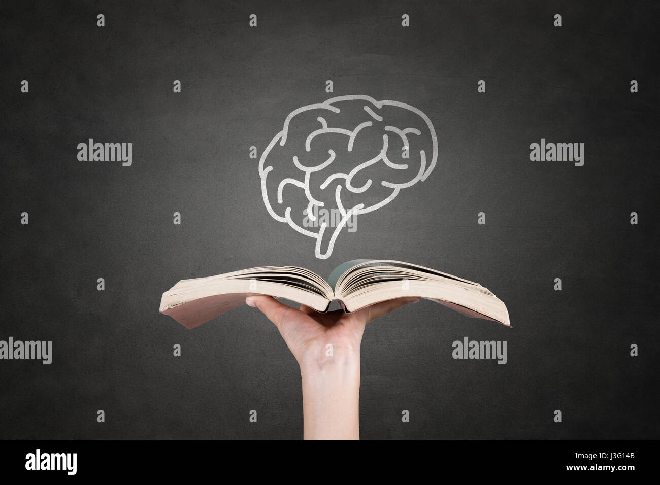Woman hand holding book in front of blackboard Banque D'Images