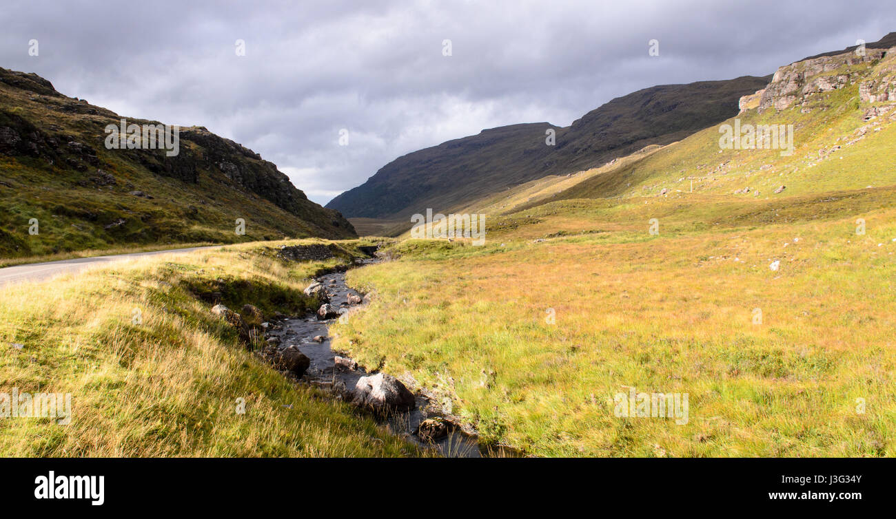 Un rocky mountain stram traverse Glen Shieldaig valley, le long de la route d'un896 Torridon. Banque D'Images