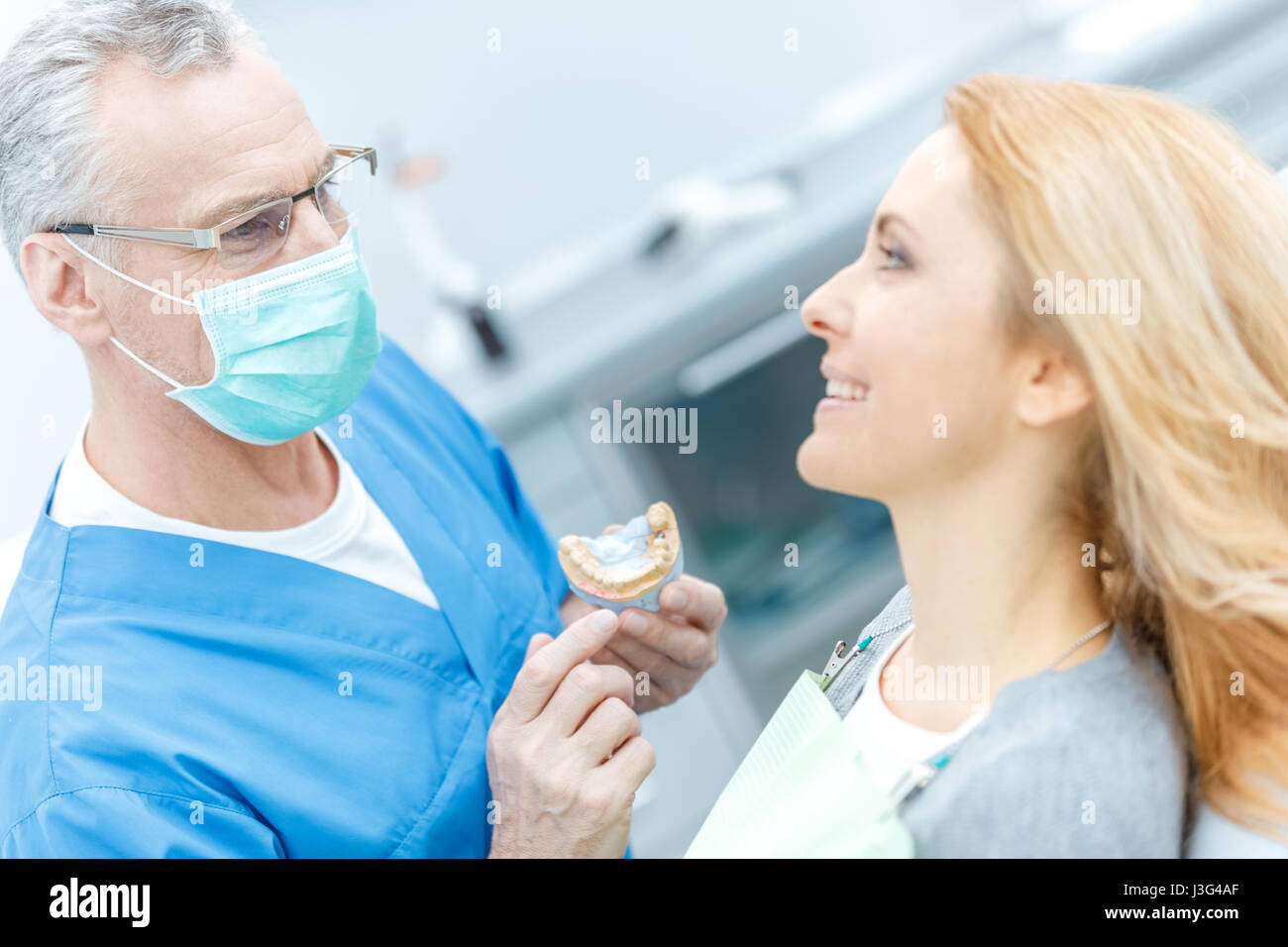 Dentist showing patient modèle à mâchoires dans une clinique dentaire Banque D'Images