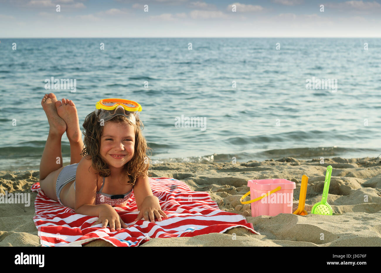 Happy little girl lying on beach saison d'été Photo Stock Alamy