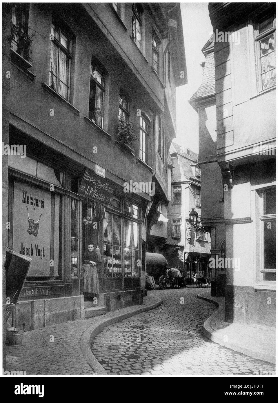 Cette réimpression présente la vue historique de l'entrée du 'Hinter dem Laemmchen' à Francfort, une partie de l'ancien marché. L'image reflète le style architectural et l'aménagement urbain de la ville dans les temps anciens, offrant un aperçu du riche passé historique et culturel de Francfort. Banque D'Images