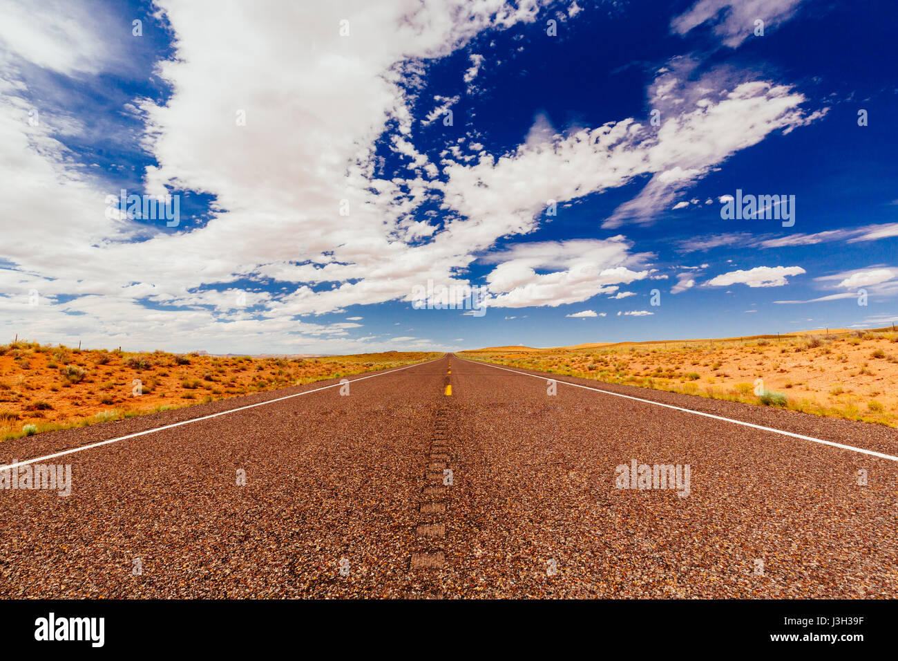 La route est la distance. De l'autre côté de la route parfaitement lisse dans un désert Emery County, Utah, USA. Banque D'Images
