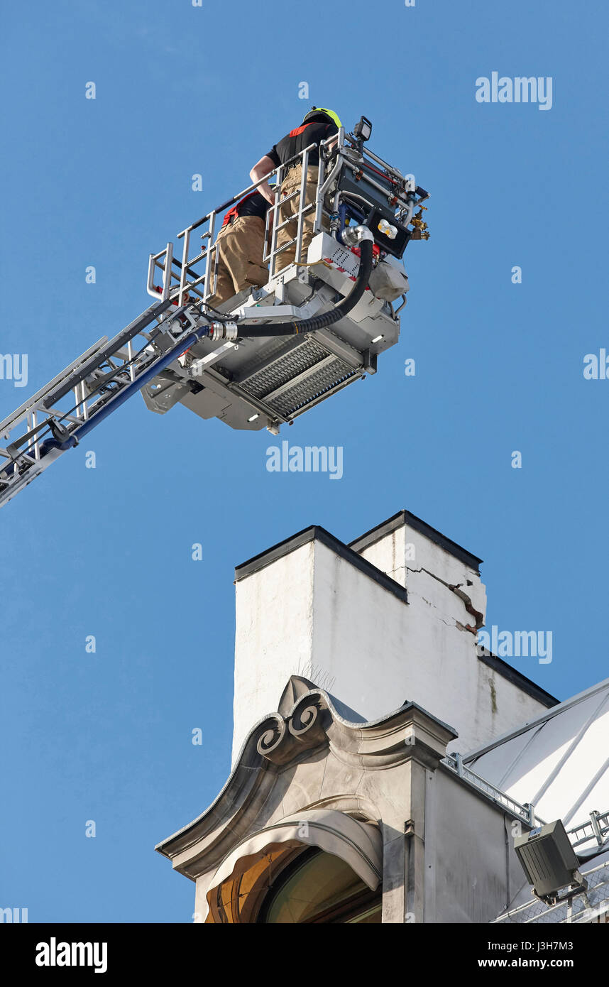 Les pompiers sur une grue la fixation d'une structure de bâtiments. Travailler Banque D'Images