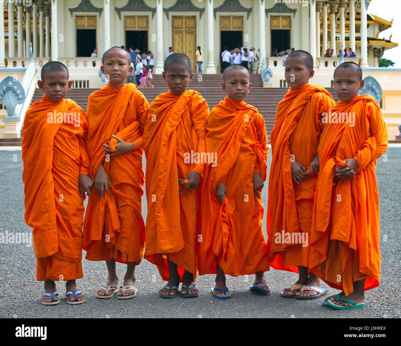 Les moines novices posant devant la salle du trône du Palais Royal, Phnom Penh, Cambodge. Banque D'Images