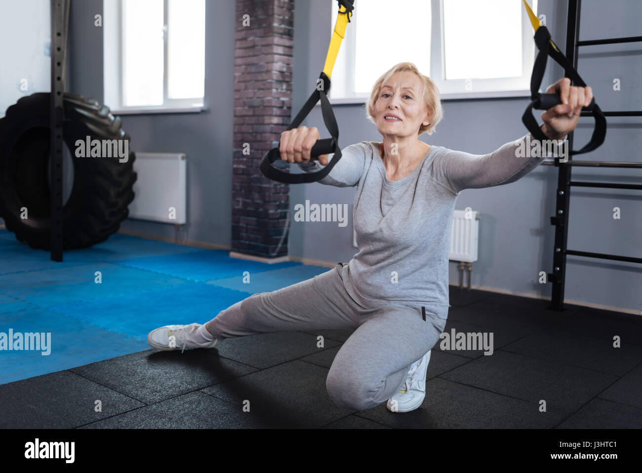 Être concentré. Nice positif femme âgée de faire un exercice physique et de se concentrer sur elle tout en visitant un centre sportif Banque D'Images