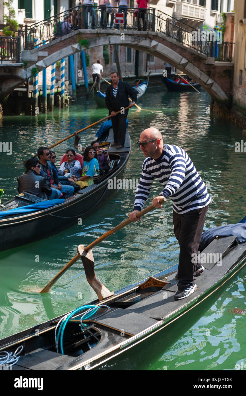 Venise, Italie - CIRCA AVRIL 2013 : gondolier vénitien plates ses eaux vert le long de la gondole d'un canal. Banque D'Images