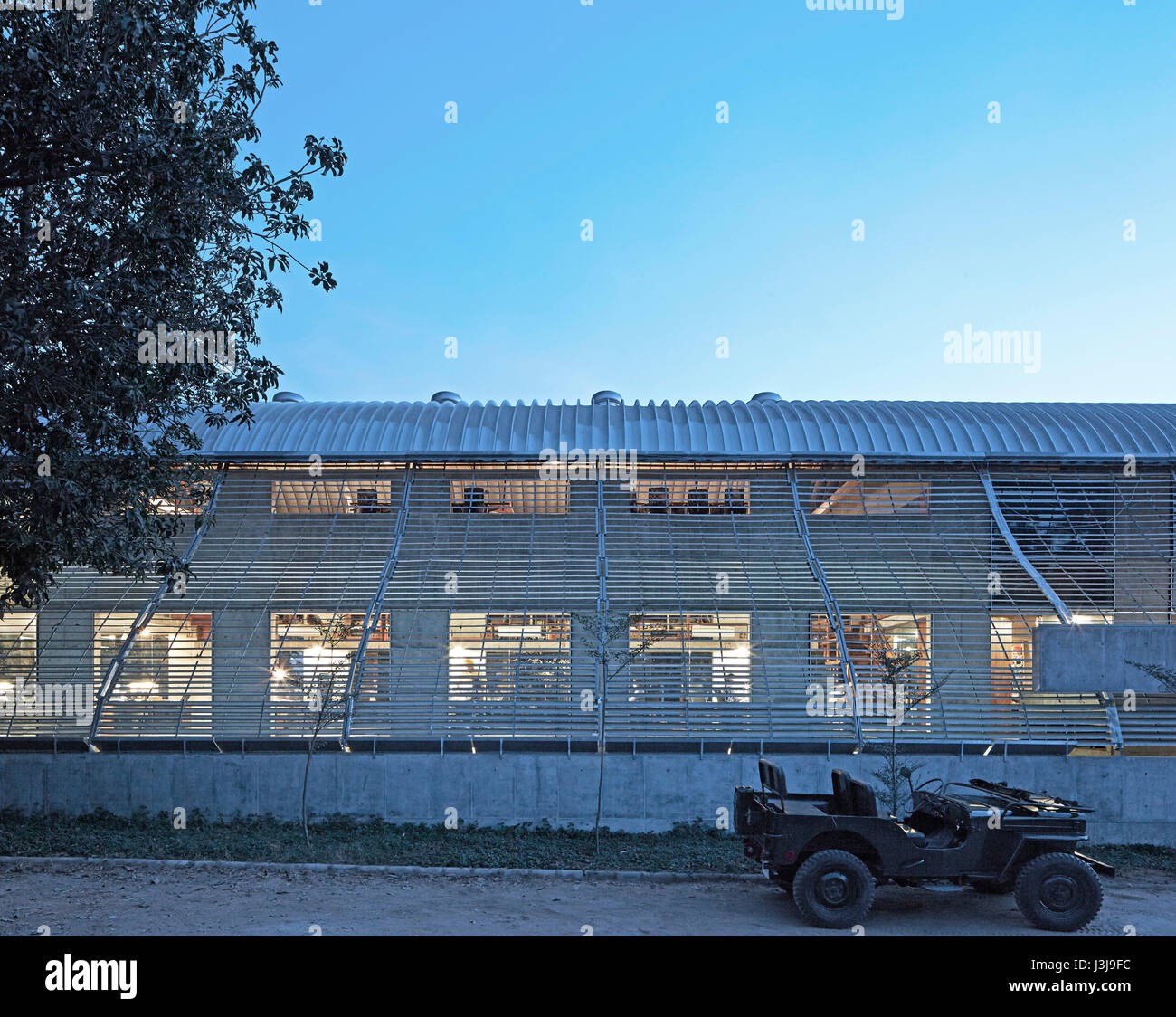 Vue extérieure côté rue au crépuscule. Le Pool Studio de Matharoo Associates, Ahmedabad, Inde. Architecte : Matharoo Associates, 2016. Banque D'Images