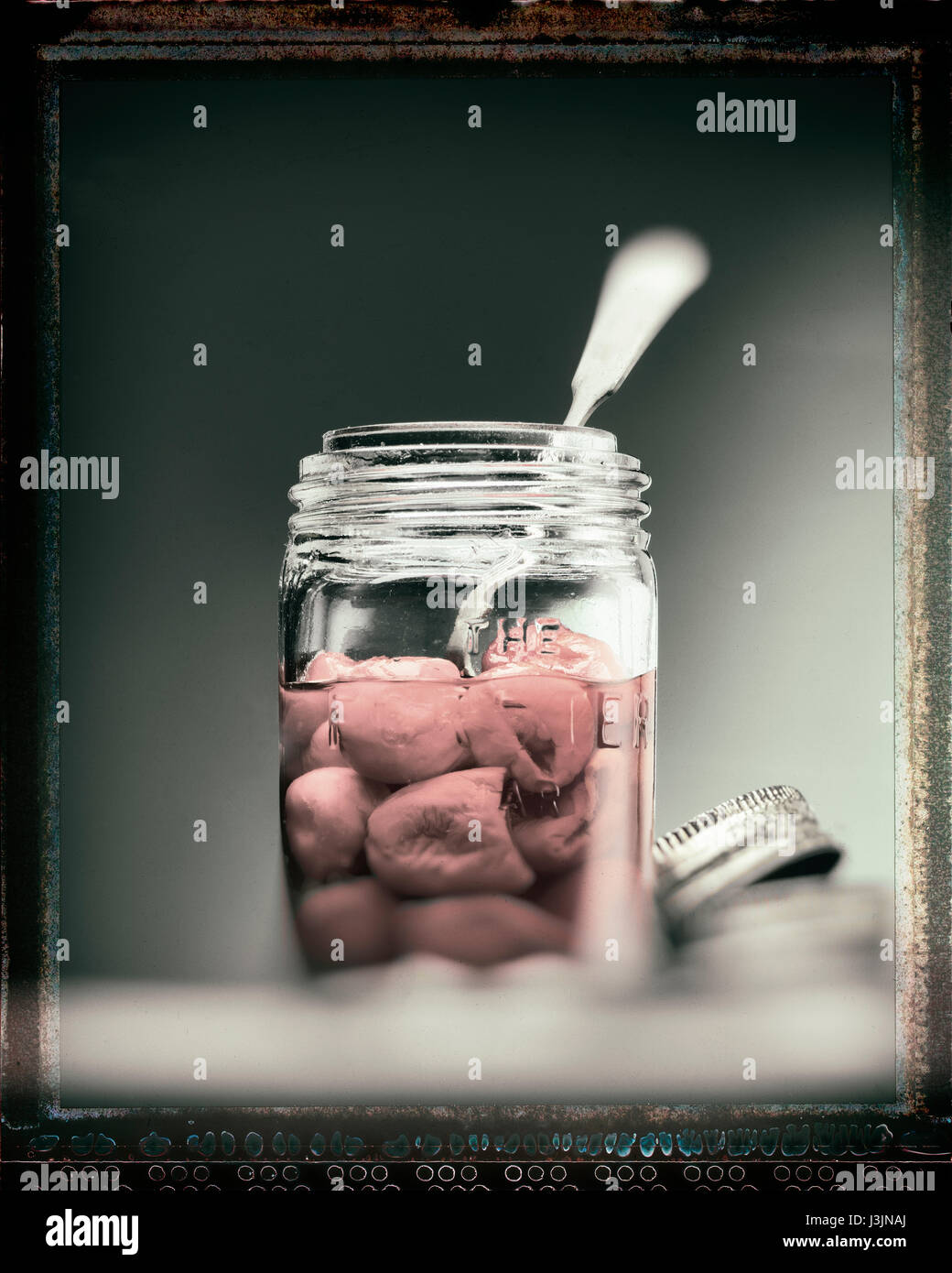 Les poivrons dans un bocal en verre avec une cuillère Banque D'Images