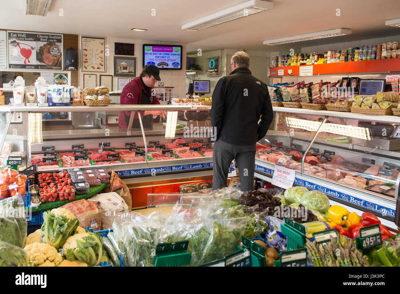 Boucherie - Kenneth Morrison Ltd, l'artisanat local traditionnel servant des clients masculins boucher, Gairloch, Ecosse, Royaume-Uni Banque D'Images