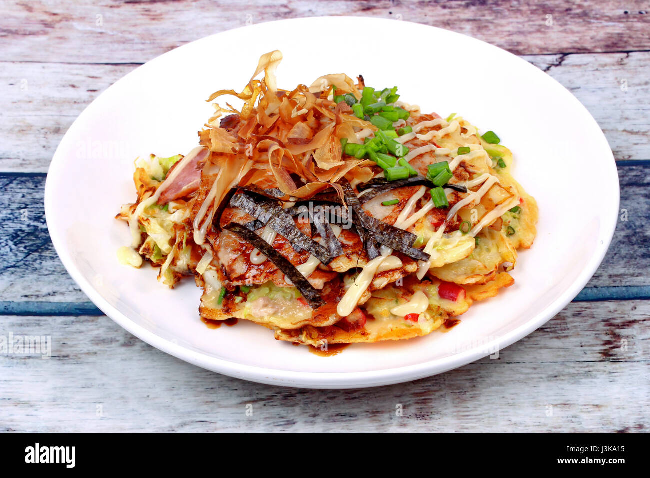 Okonomiyaki (Crêpe Chou japonais) est frit Recette farine de légumes mélangés avec de la viande garnie sauce douce ,la mayonnaise et les tranches de thon séché Banque D'Images