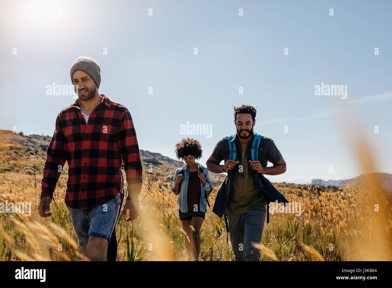 Trois jeunes amis sur un pays de marche. Groupe de personnes la randonnée à travers la campagne. Banque D'Images