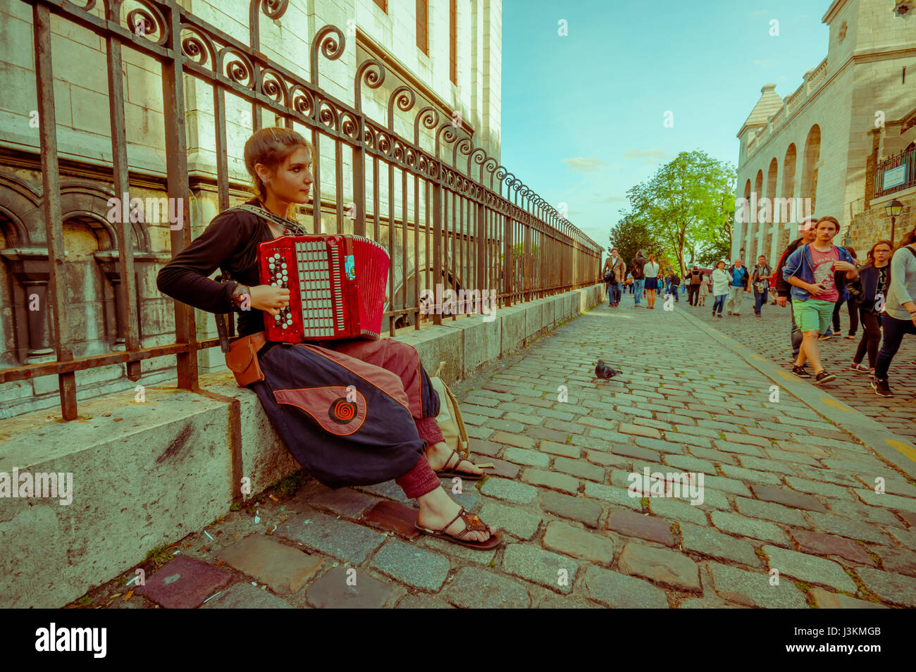 Paris, France 1 juin 2015 : gypsy woman sitting on mur de béton et de jouer l'accordéon, autour de la rue bohème célèbre Montmartre . Banque D'Images