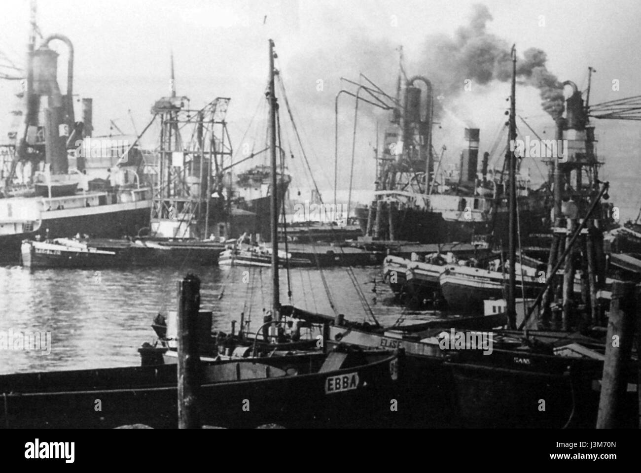 Cette image de 1932 montre l'utilisation d'une « grue aspirante » (saugheber) dans le port de charbon de Hambourg, reflétant les pratiques industrielles de l'époque. Banque D'Images