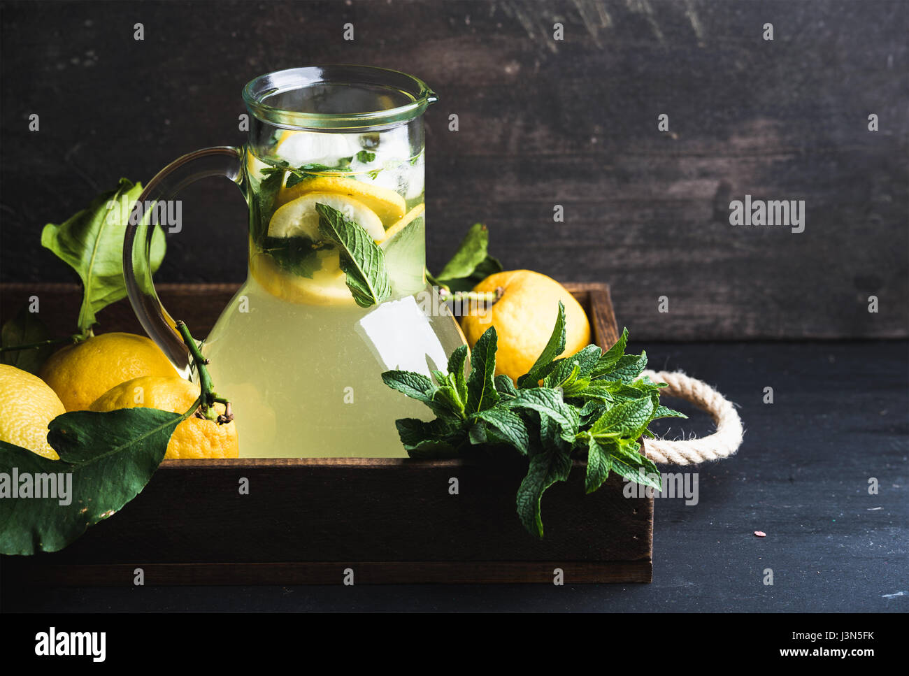 Limonade à la menthe fait maison servi avec des citrons frais et glace sur fond de bois, vue du dessus, copy space Banque D'Images