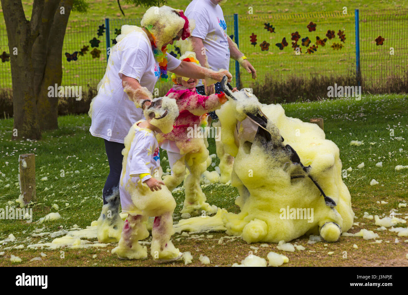 Weymouth, Dorset, UK. 7 mai, 2017. La bulle de Weldmar Rush a lieu à Weymouth pour lever des fonds pour l'organisme de bienfaisance avec environ 2000 personnes qui sont attendues pour prendre part, dans des bulles de couleurs différentes. Les enfants et poussette buggy couvert de mousse jaune mousse de bulles ! Credit : Carolyn Jenkins/Alamy Live News Banque D'Images