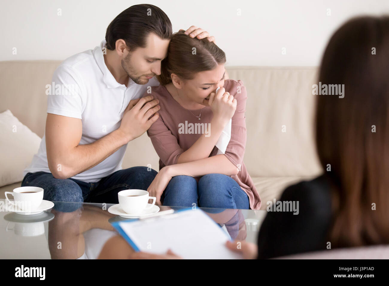 Couple Famille counseling. Triste à pleurer femme mari réconfortant à Banque D'Images