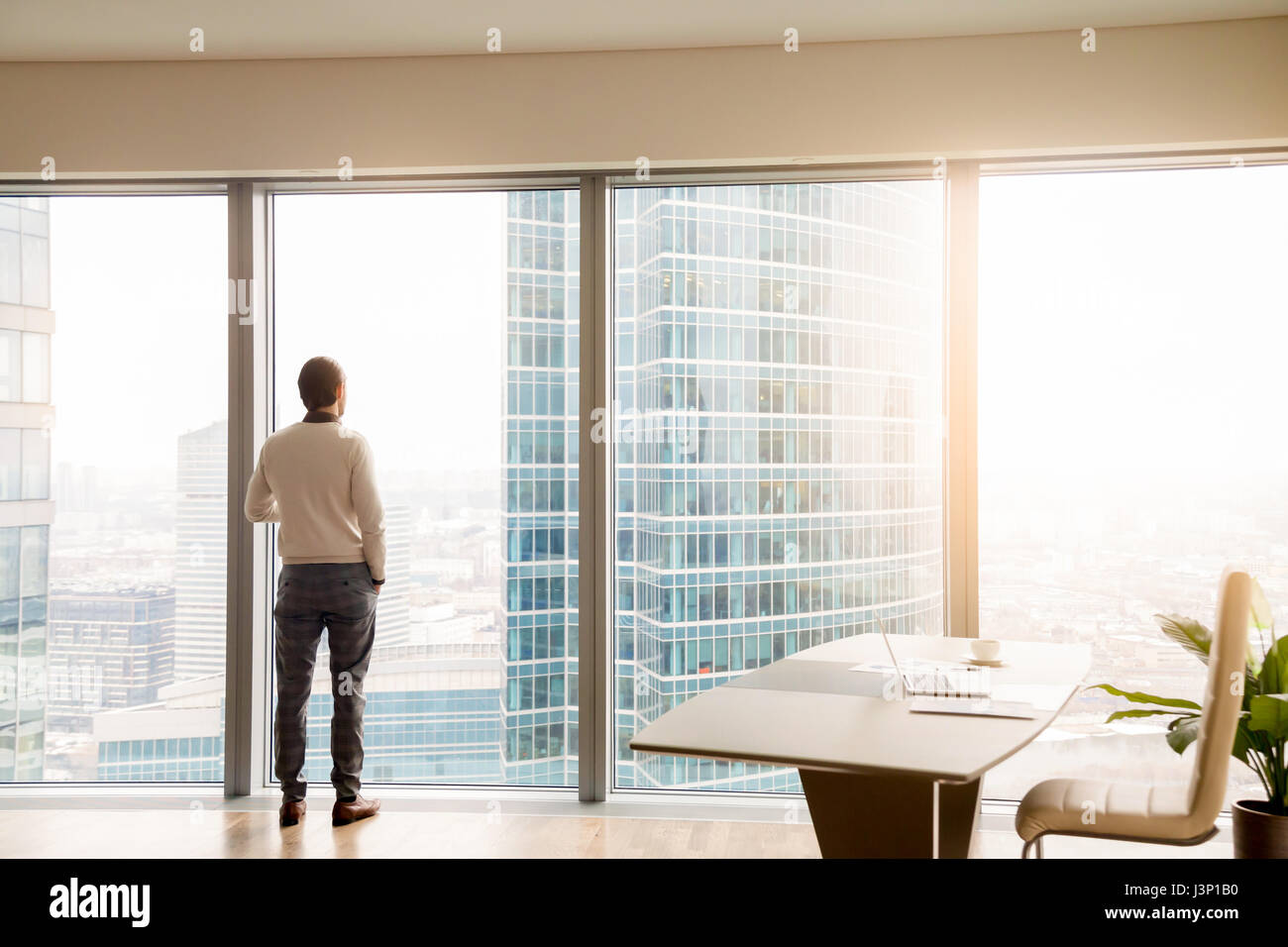 Jeune homme d'affaires réussi standing in office looking at full- Banque D'Images