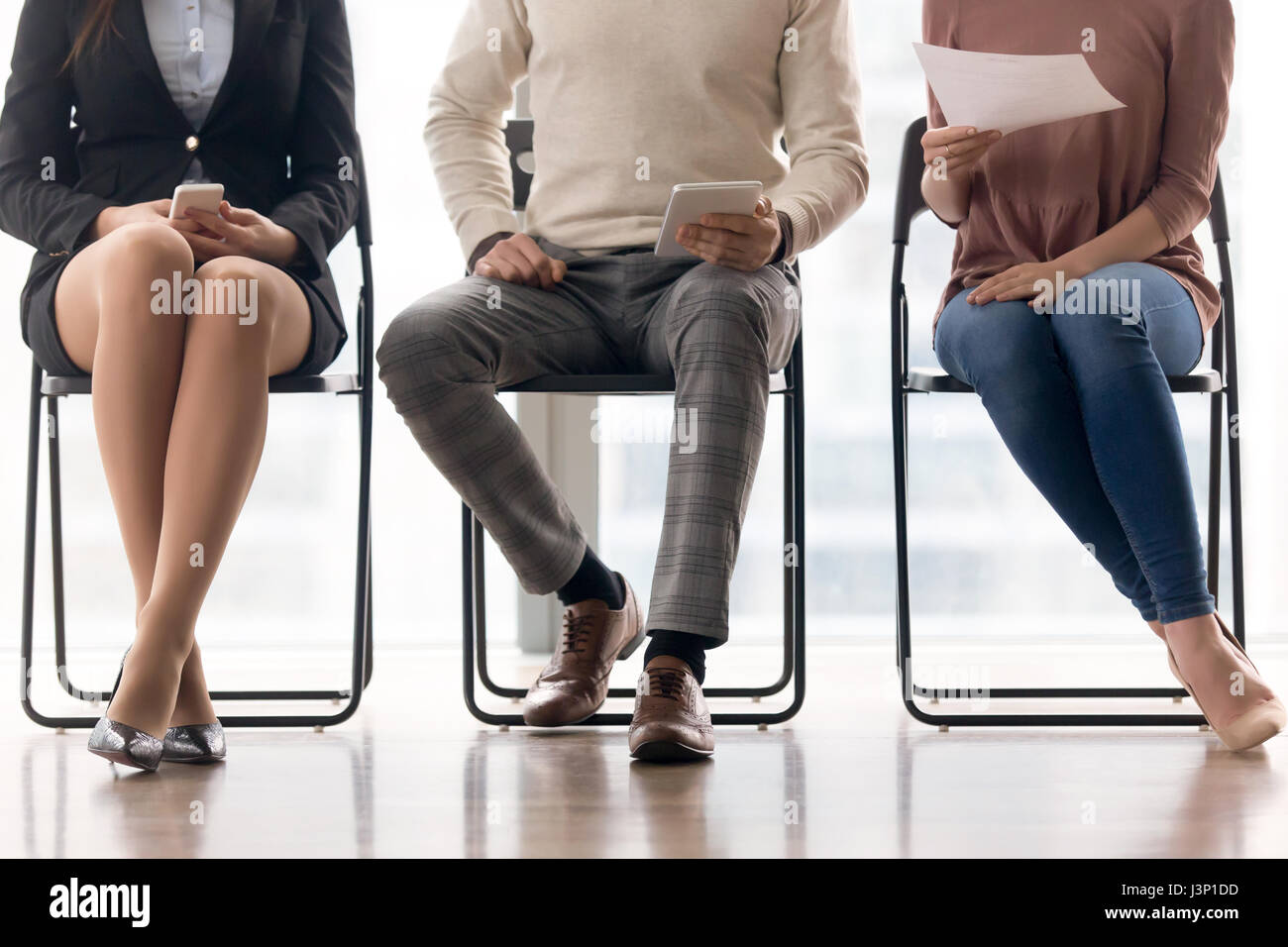 Groupe de personnes en attente d'entrevue d'emploi, assis sur des chaises Banque D'Images