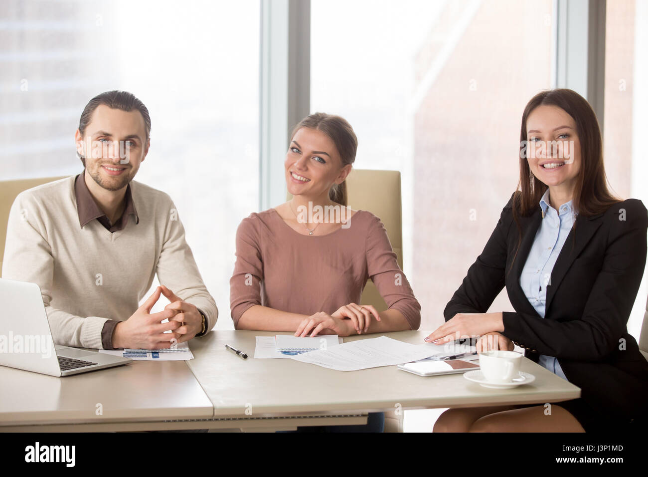 Les gens d'affaires de l'équipe office desk looking at camera Banque D'Images