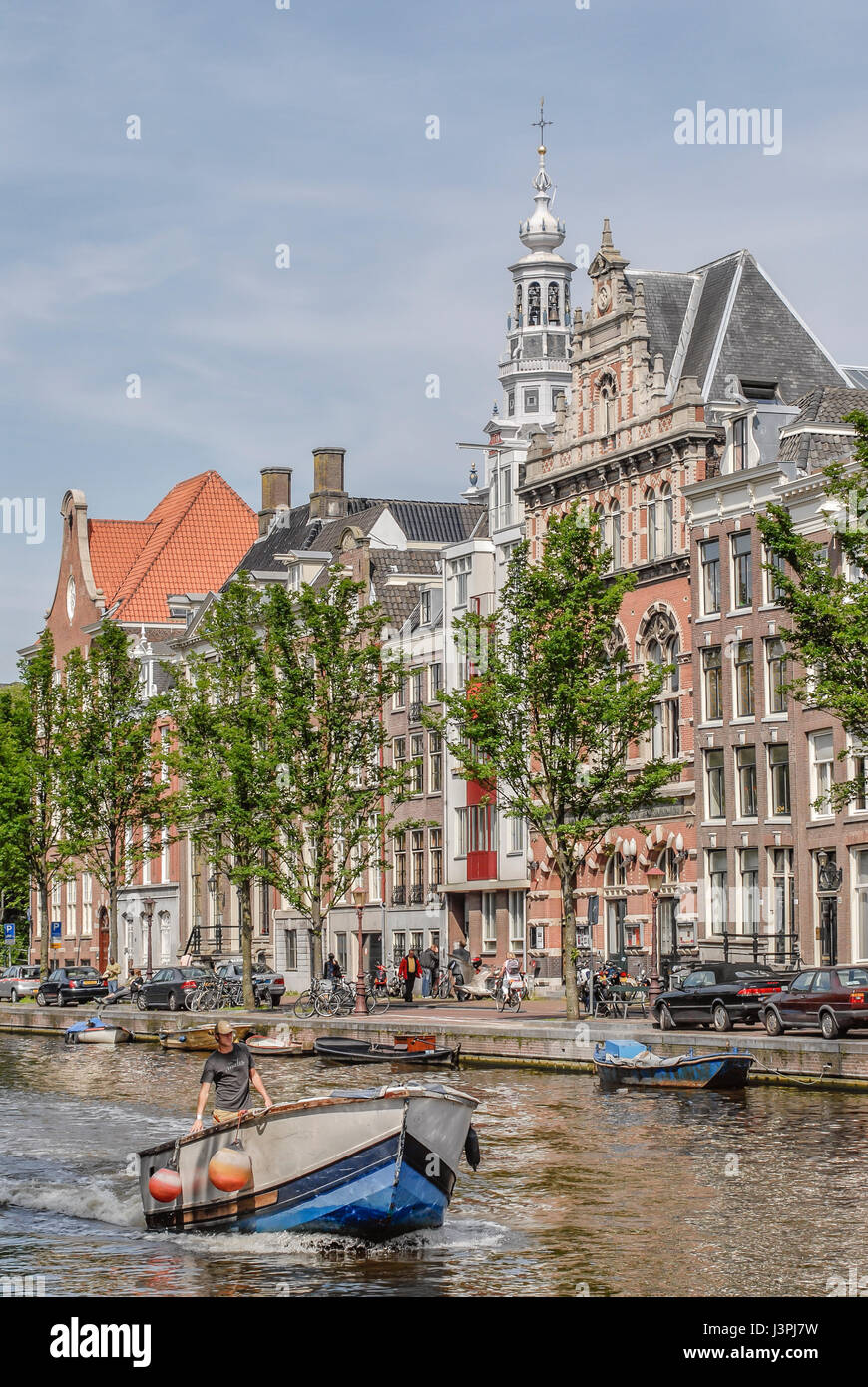 Petit bateau qui traverse un canal d'eau d'Amsterdam, Pays-Bas Banque D'Images