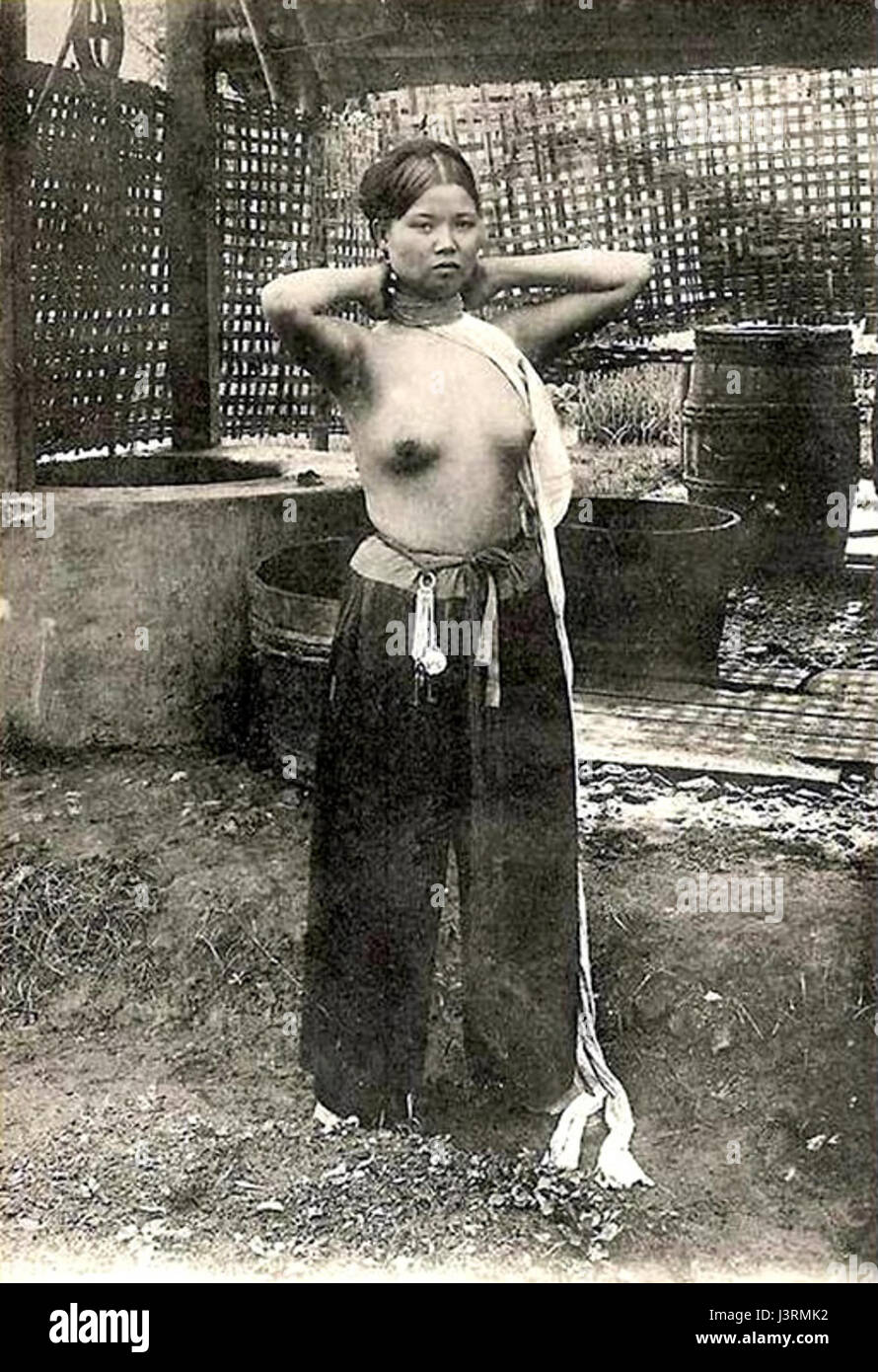 Cette œuvre, intitulée 'jeune femme annamite achevant sa toilette', représente une jeune femme vietnamienne qui termine sa préparation quotidienne. La peinture capture les aspects culturels de la vie vietnamienne et des vêtements traditionnels. Banque D'Images