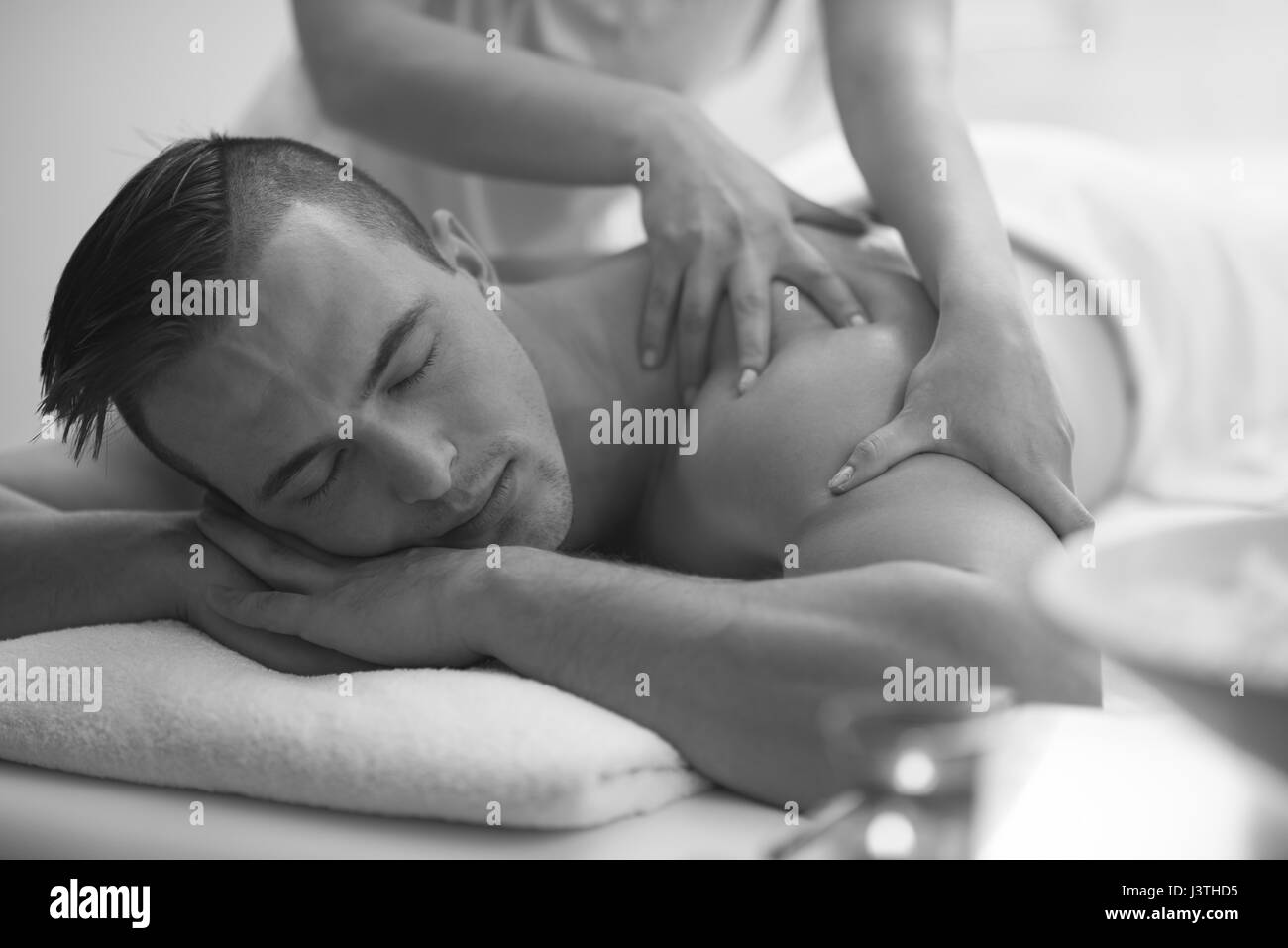 Jeune homme positif d'avoir un massage du dos dans un centre de spa Banque D'Images