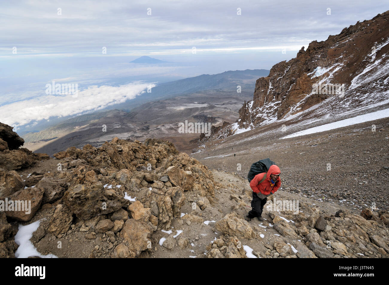 A porter l'ascension de la violation de l'Ouest avec le Mont Meru au loin, le Mont Kilimanjaro National Park, Tanzania Banque D'Images