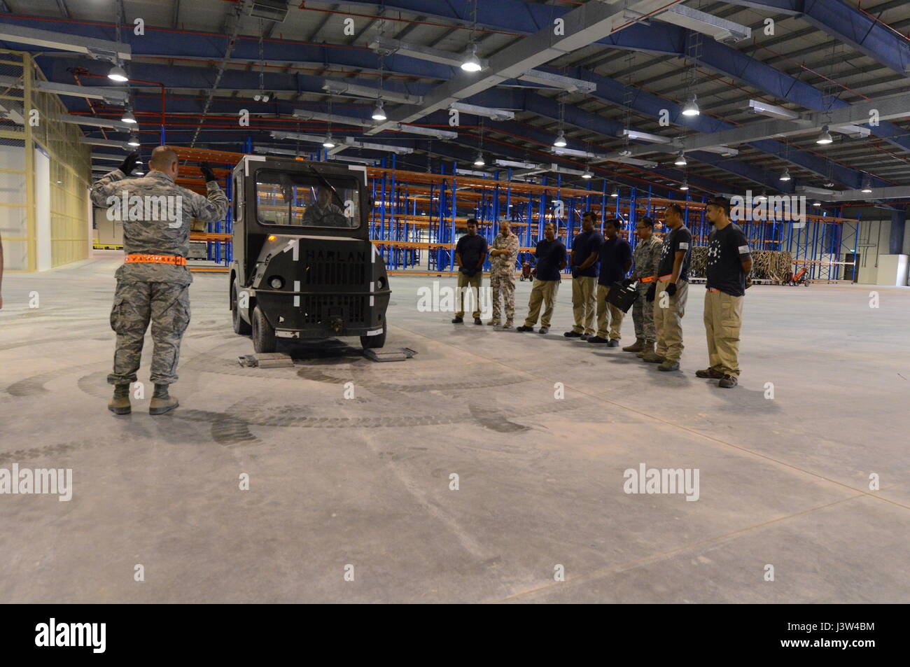 U.S. Air Force et du personnel de la Force aérienne Qatarie rassembler autour d'un véhicule à l'intérieur d'une nouvelle installation située à Al Udeid Air Base, au Qatar, le 26 avril 2017. Les membres du personnel participent à la première des nombreuses possibilités d'échange d'information afin de discuter de la façon de déterminer le poids total et le centre de gravité pour l'équipement en cours de chargement pour le transport à bord des aéronefs. Banque D'Images