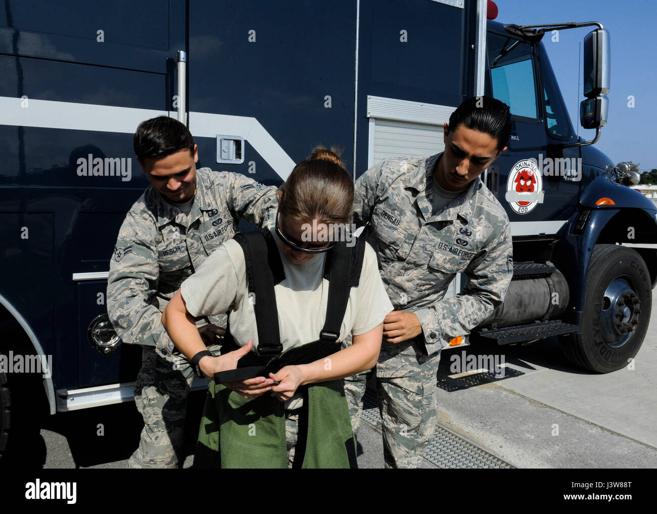 Les aviateurs de l'US Air Force 1re classe Anthony Beschi et Quentin Deneau, 18e Escadron de Génie Civil des explosifs et munitions, d'aider les apprentis Tech. Le Sgt. Rebecca Kimberling, 18e conférence de l'offre de NEM sous-officier responsable, comme elle se fait dans un dossier obstétrical combinaison antibombe 4 mai 2017, à Kadena Air Base, au Japon. Réaction de neutralisation des explosifs a été rendu possible grâce à la dynamique de groupe entre les sous-officiers et aviateurs. (U.S. Photo de l'Armée de l'air par la Haute Airman Lynette M. Rolen) Banque D'Images