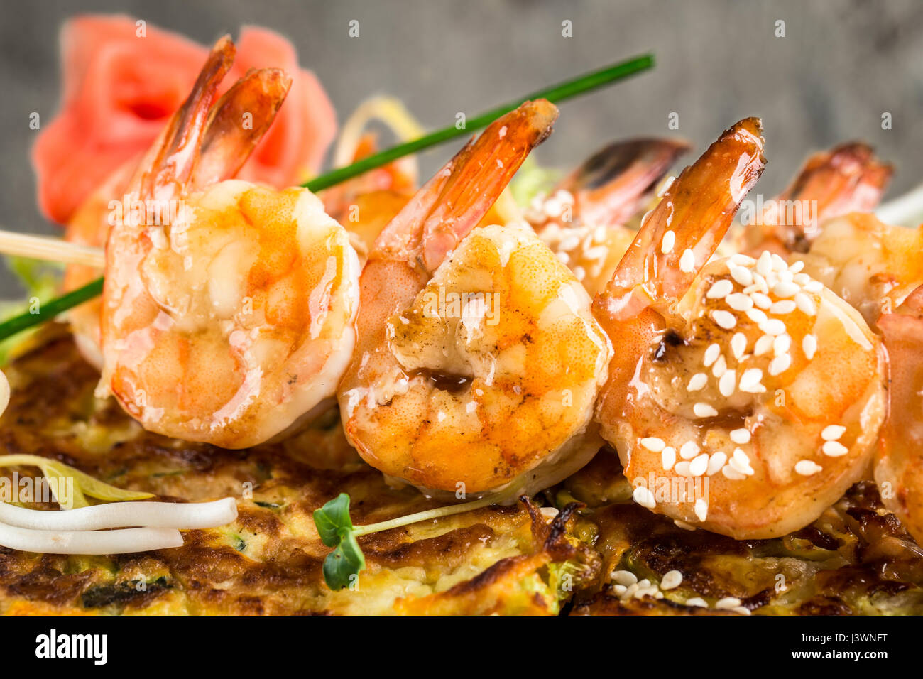 Close up of les brochettes de crevettes sur l'omelette aux légumes Banque D'Images
