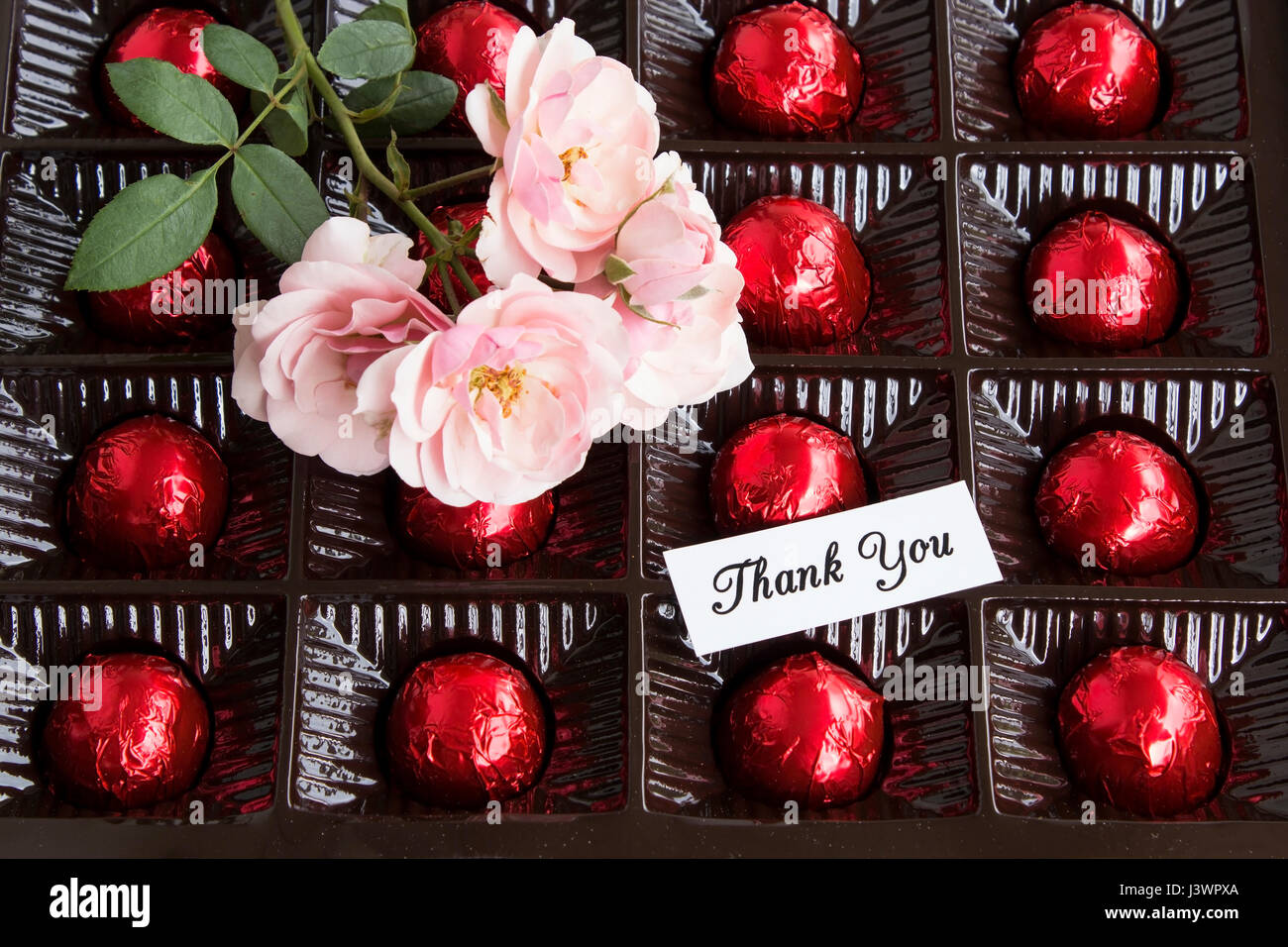 Carte de remerciement avec une boîte de pralines et Roses. Banque D'Images