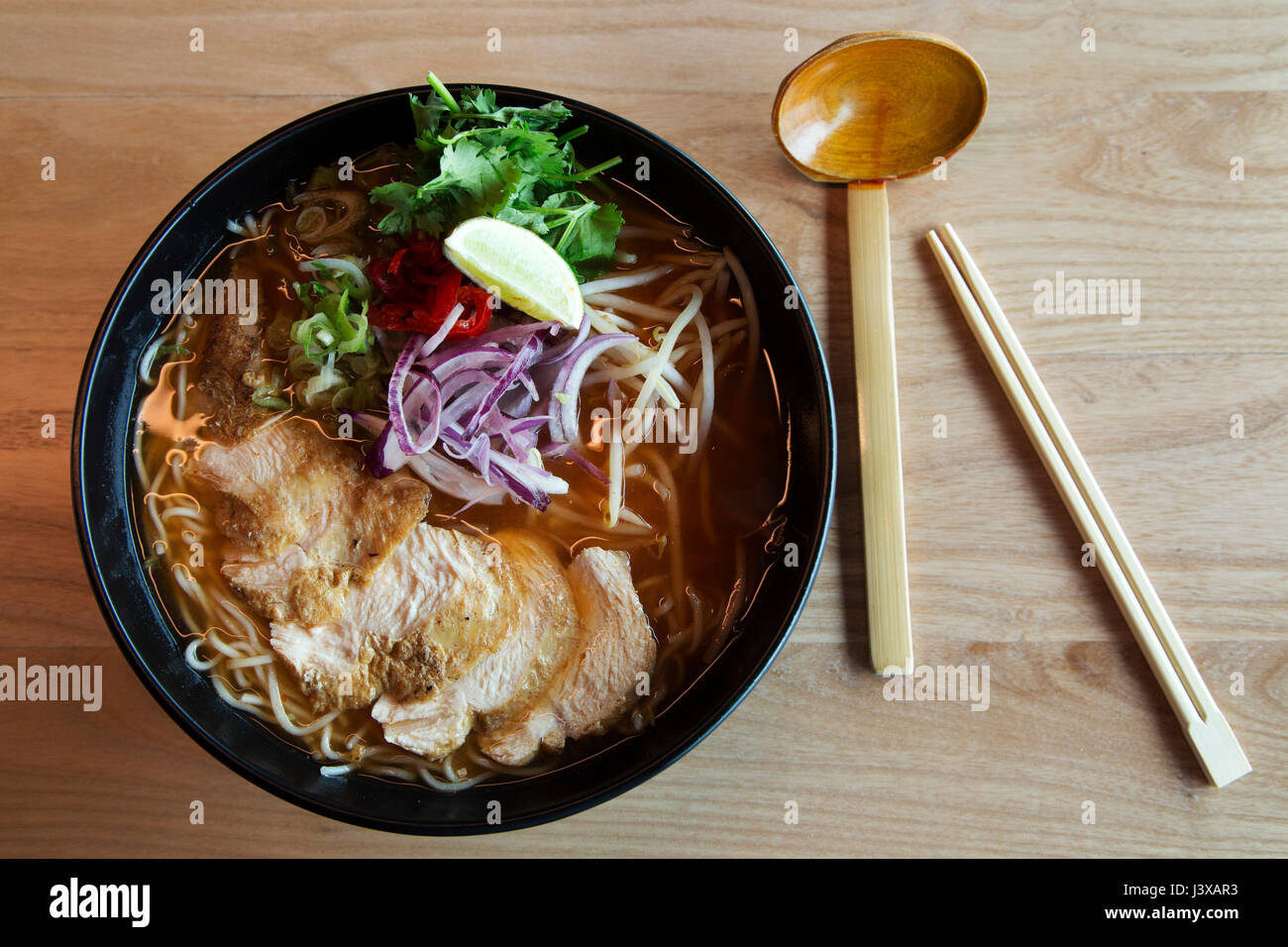 Un bol de chili nouilles poulet servi avec des légumes. Nouilles Ramen est un plat asiatique. Banque D'Images