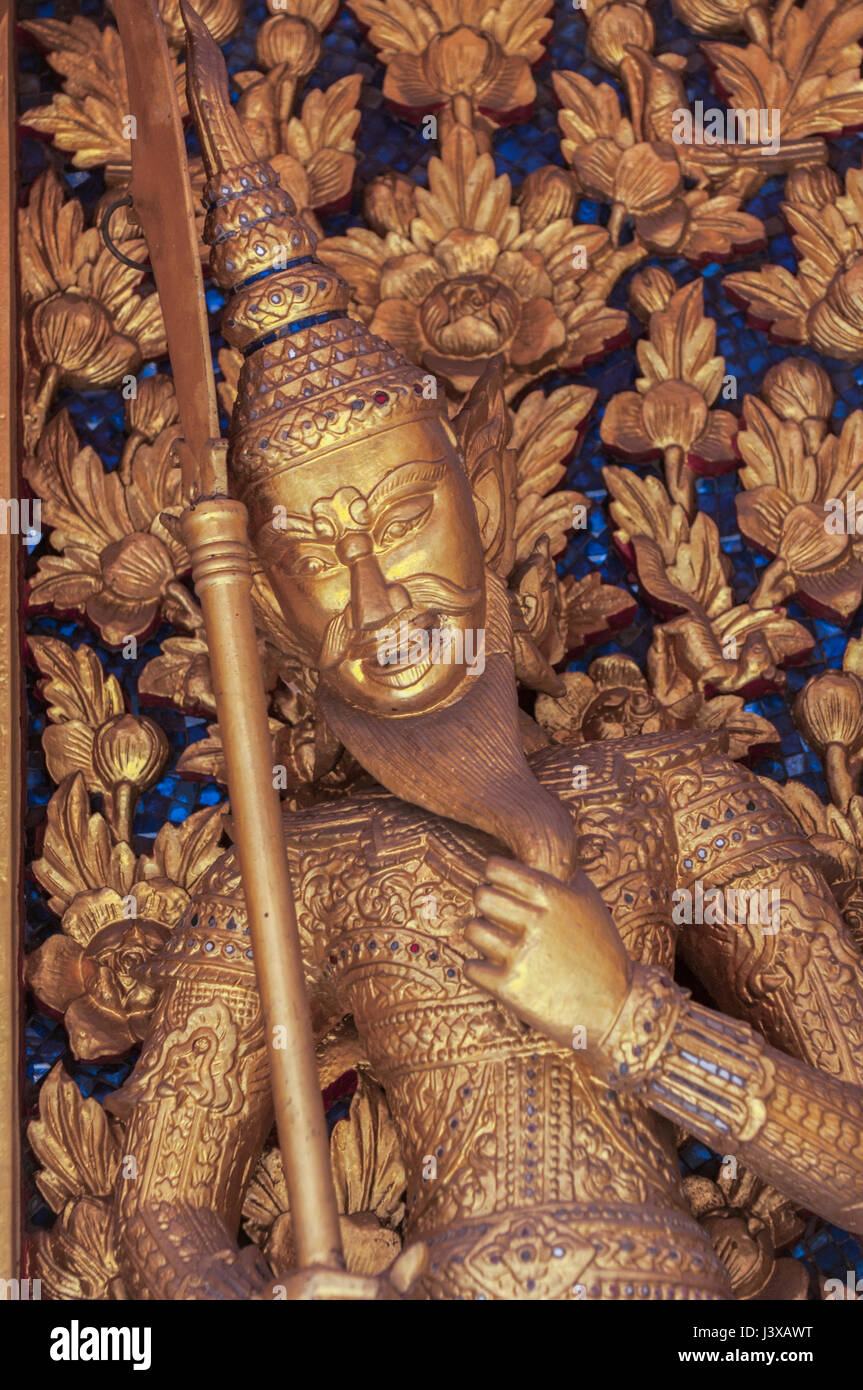 Un guerrier d'or représenté sur une frise dans le parc du Temple du Bouddha Émeraude Banque D'Images