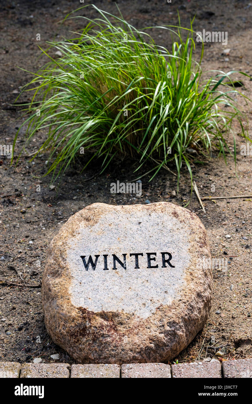 Hiver mot écrit, gravé, gaufrage, sur un jardin décoratif pierre, saisons de l'année, décoration, jardin, pierre pierre ornementale, signe d'hiver. Banque D'Images