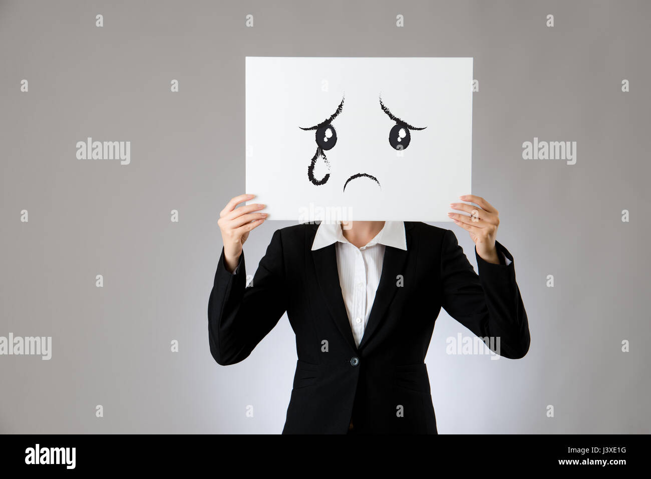 Pleurs et tristesse face à un dessin d'expression case white poster holding par une femme d'affaires. isolé sur fond gris. business office company con Banque D'Images