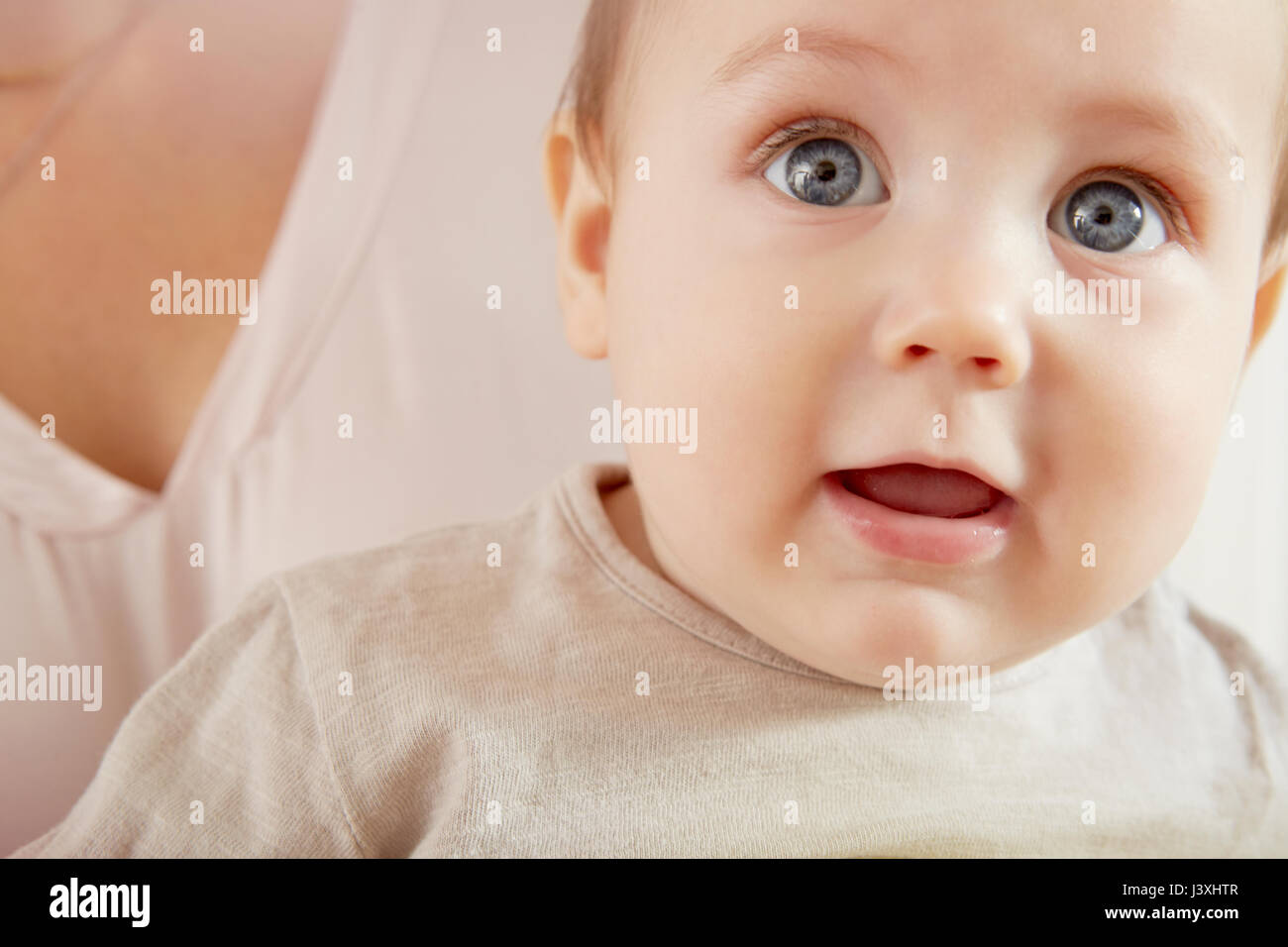 Close up of blue eyed baby boy Porté par mère Banque D'Images