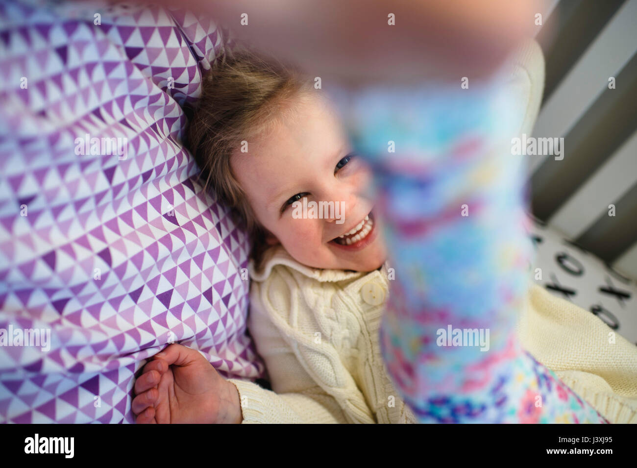 Girl laughing en jouant sur lit de jour Banque D'Images