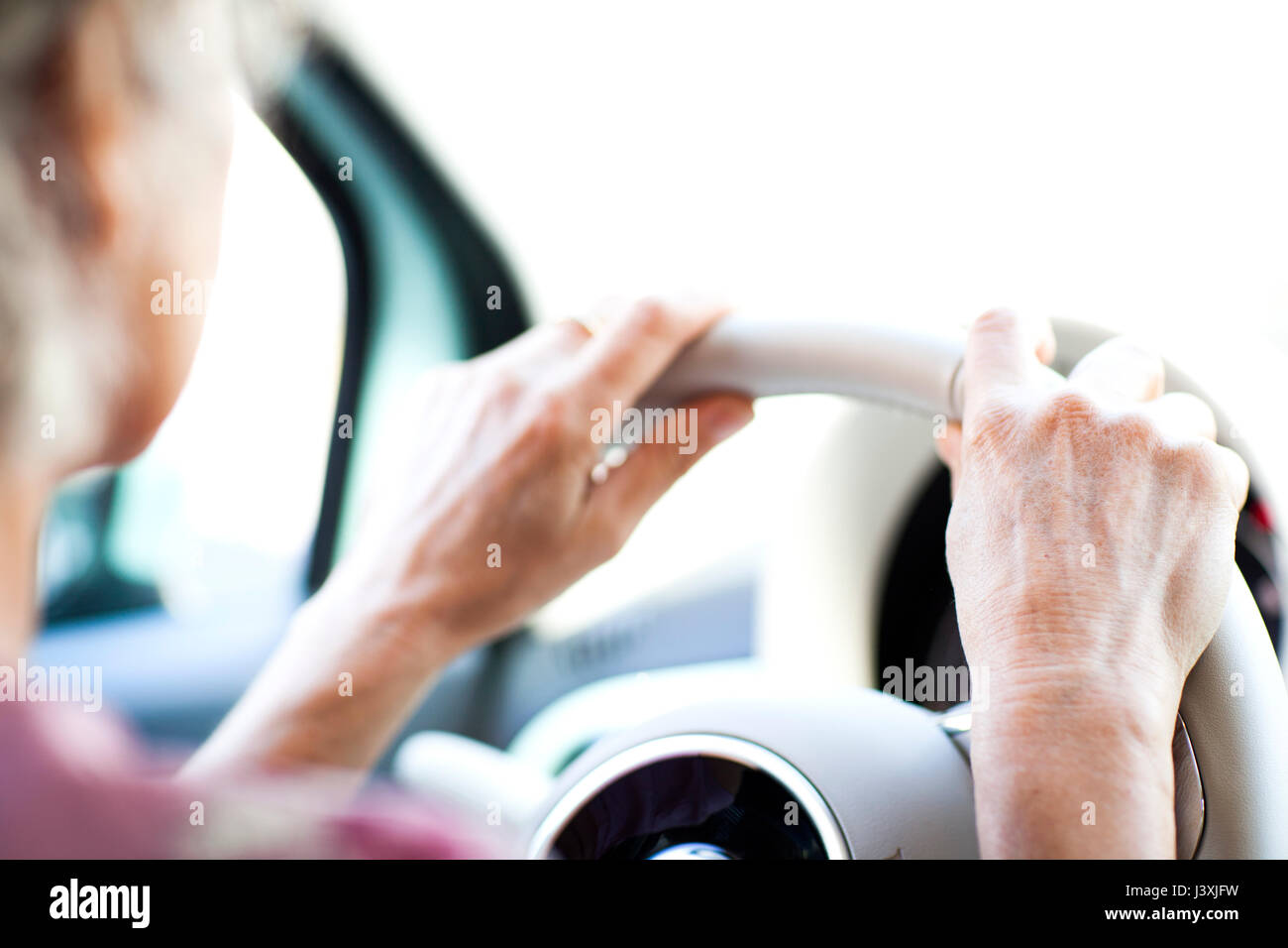 Mains de femme mature sur volant de voiture Banque D'Images