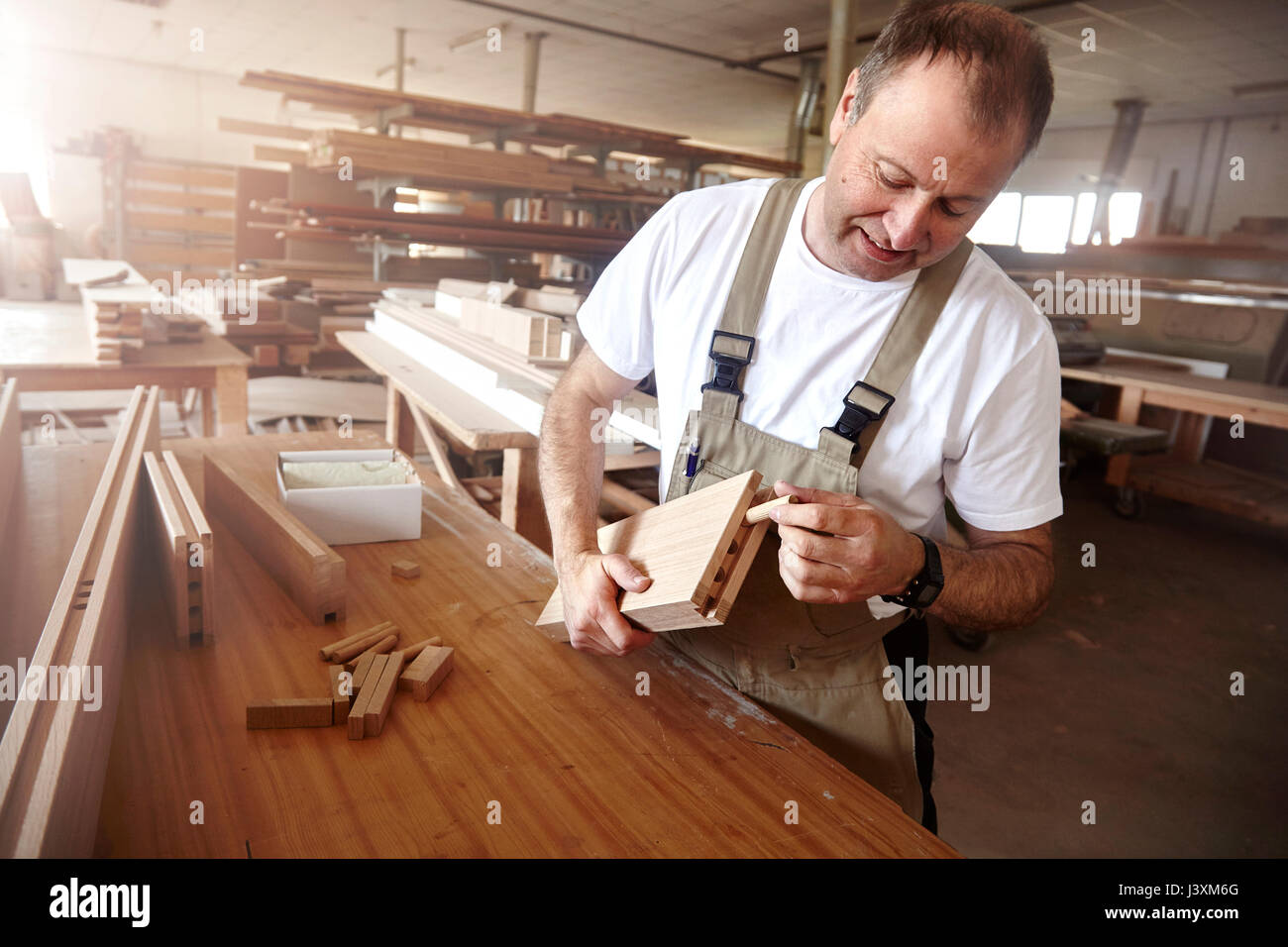 Male carpenter insertion de cheville en bois à l'établi Banque D'Images