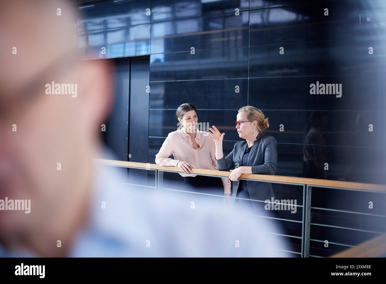 Deux businesswomen having discussion sur balcon bureau Banque D'Images