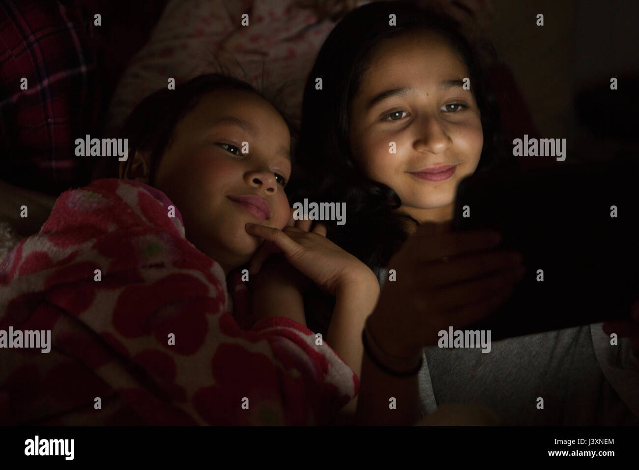 Slumber Party Girls using digital tablet Banque D'Images