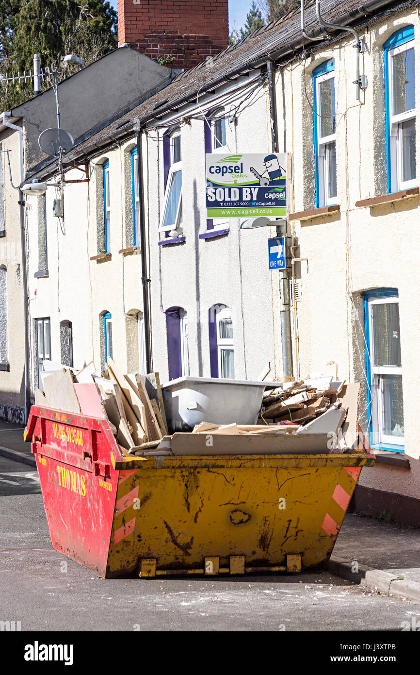 Passer des déchets contenant une baignoire à l'extérieur d'un vendu signe sur Galles, UK Banque D'Images